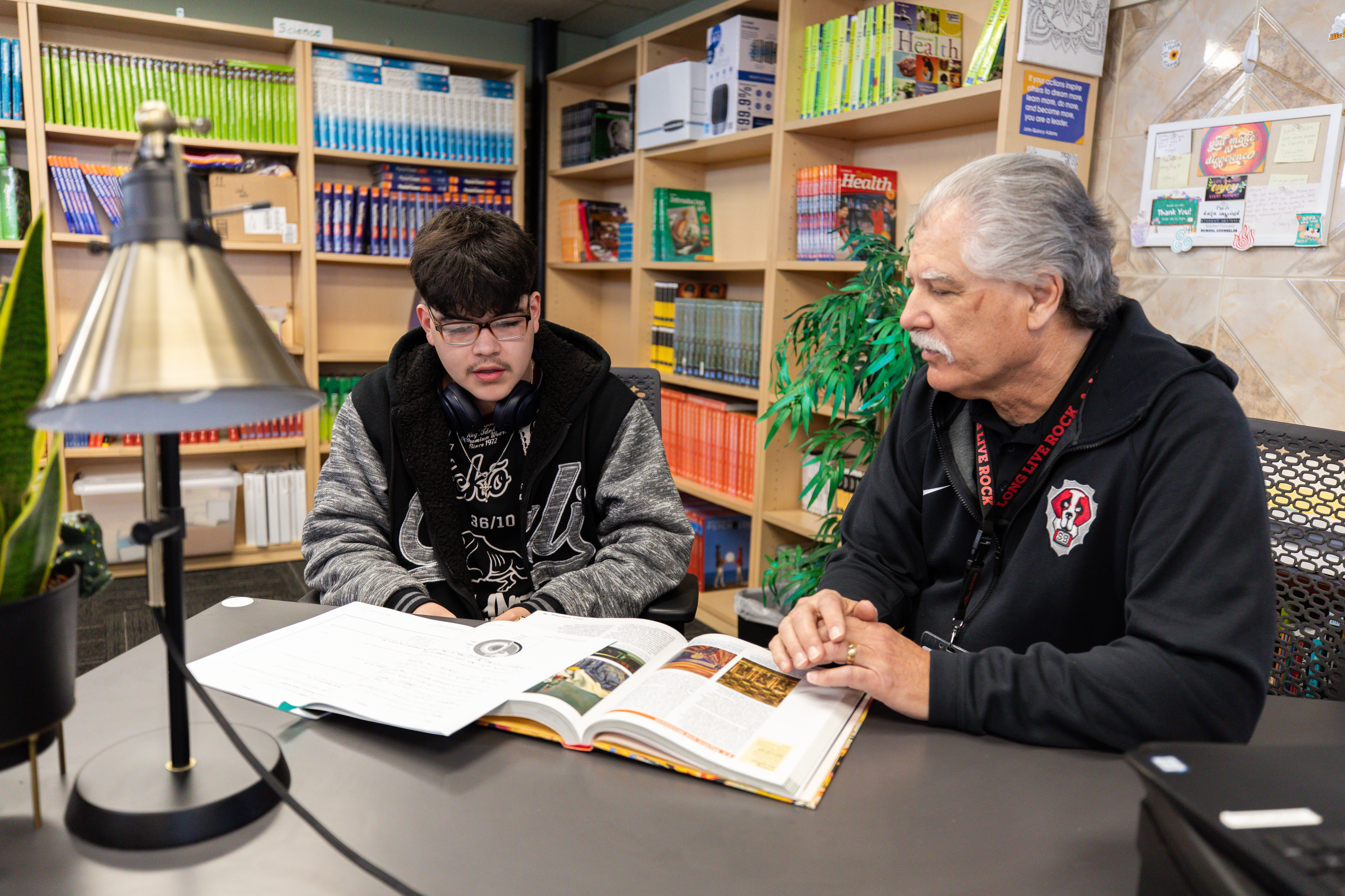 A student working in a classroom with a teacher.
